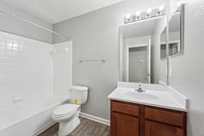 A white toilet sits next to a white sink in a small bathroom.